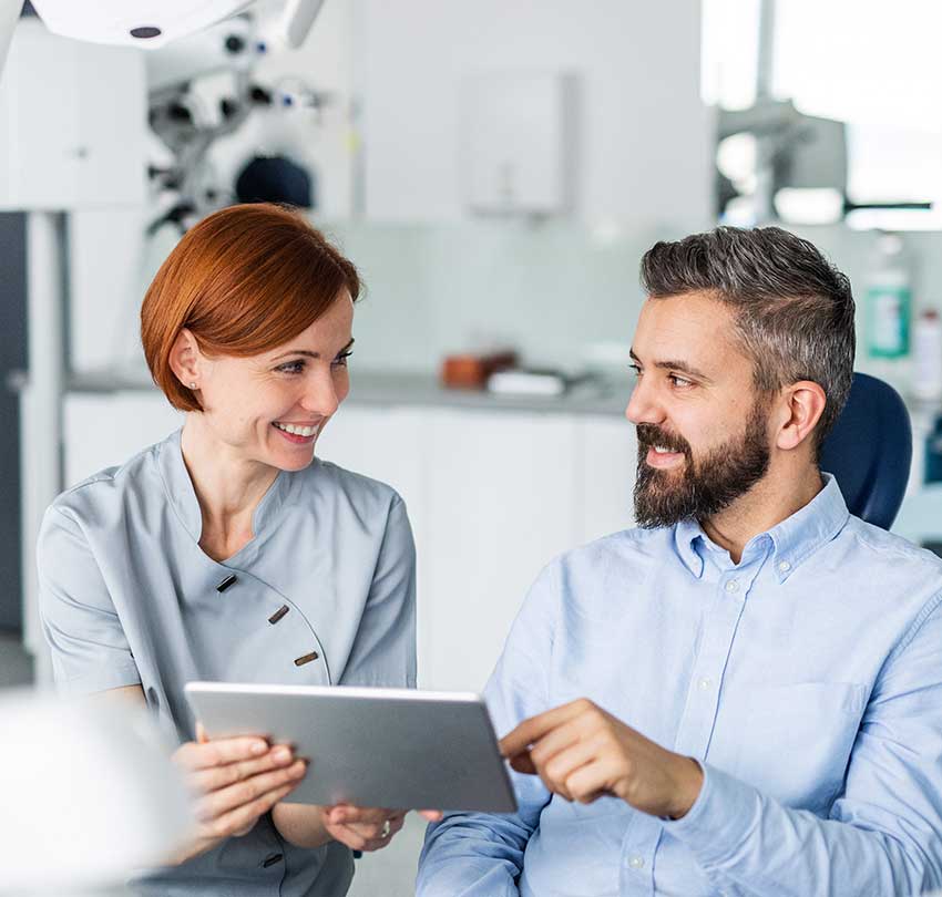 Man-and-dentist-with-tablet-in-dental-surgery,-annual-check-up.-850x810